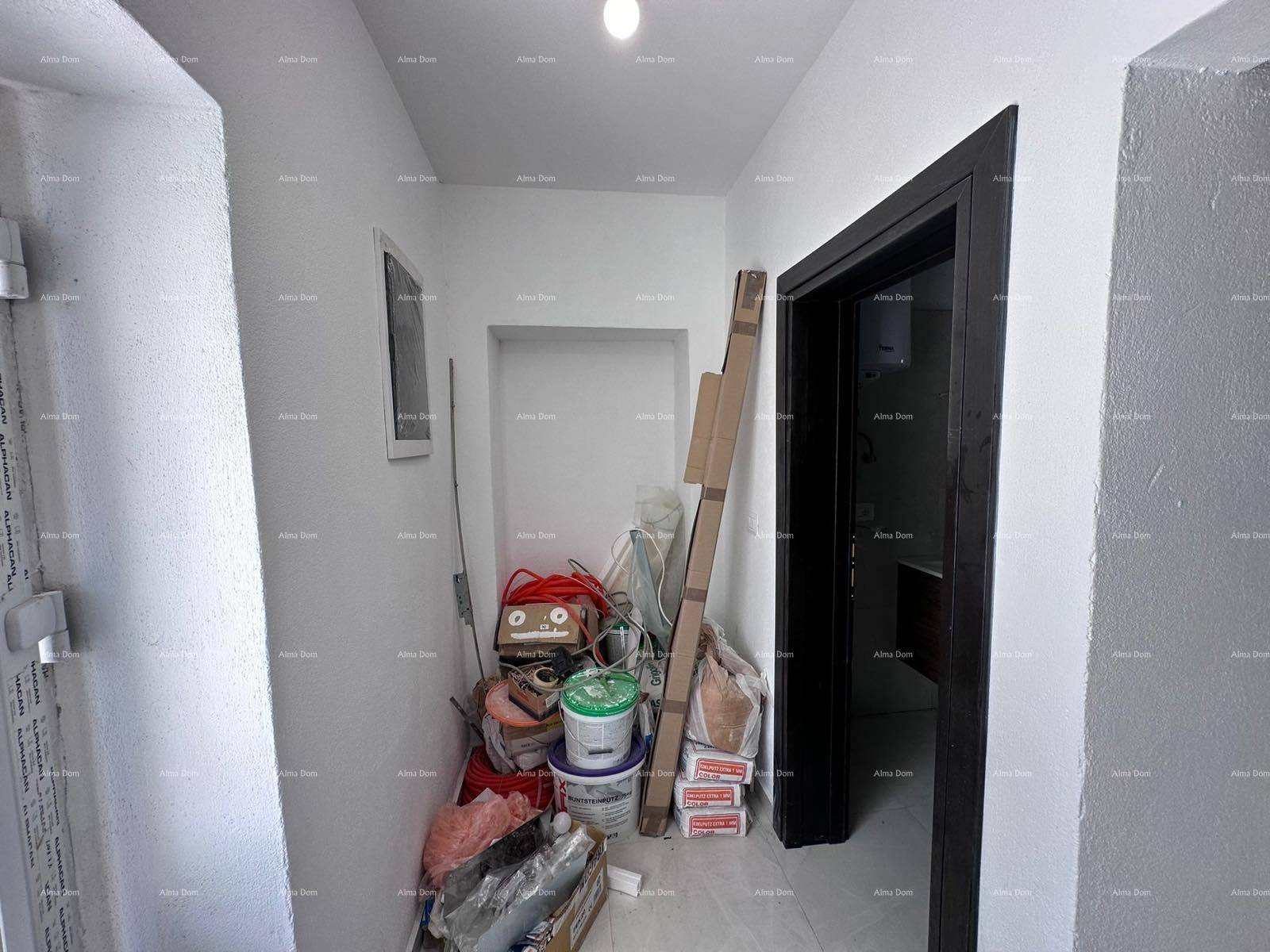 Flur mit Baumaterialien und einer dunklen Tür, der auf eine Baustelle hindeutet.