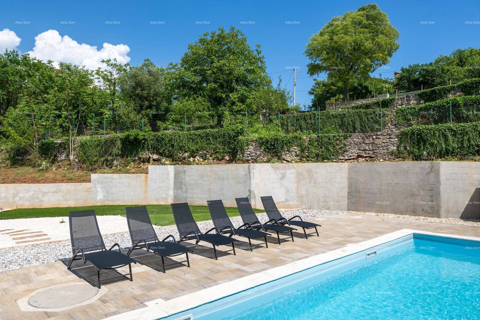Entspannungsbereich am Pool mit mehreren Liegestühlen und terrassiertem Garten im Hintergrund.
