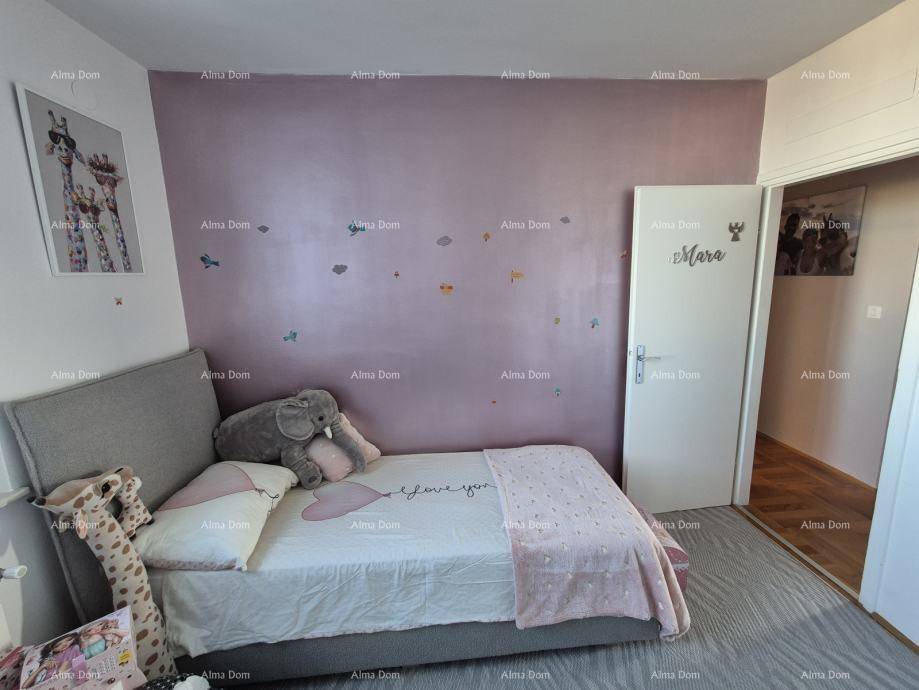 Kinderzimmer mit Einzelbett, rosa Wand und weichem Teppichboden, liebevoll dekoriert.