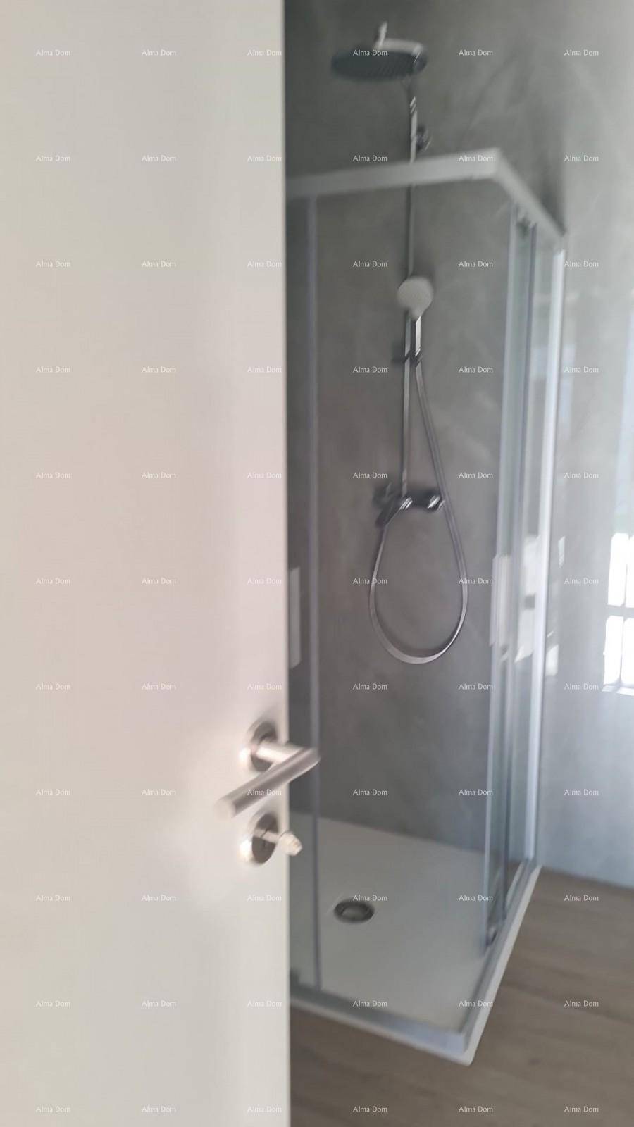 Modernes Badezimmer mit Duschkabine und Regendusche, teilweise sichtbar durch die Tür.