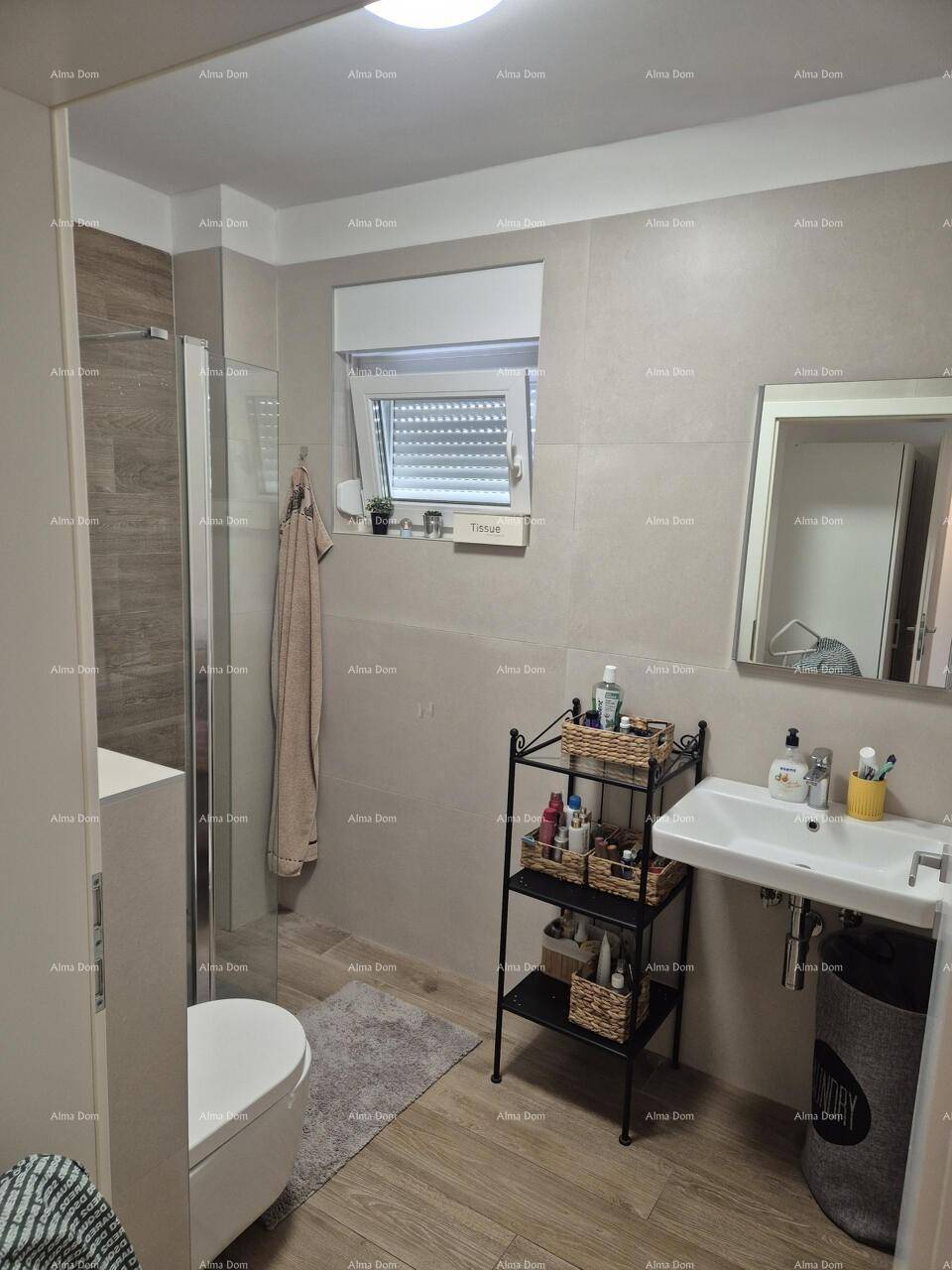 Helles Badezimmer mit Dusche, Waschbecken und praktischen Ablagemöglichkeiten.