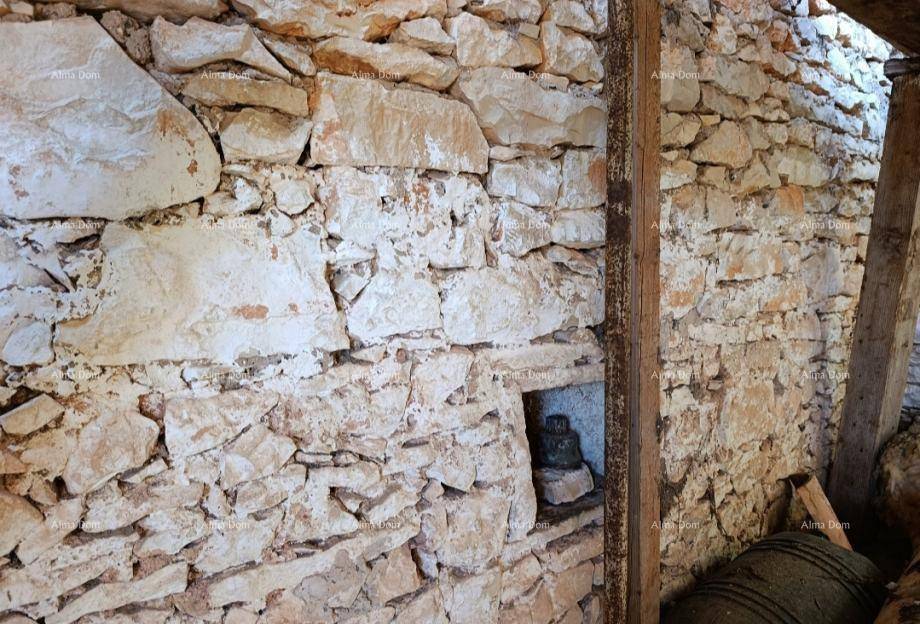Innenansicht einer groben Steinmauer mit einer kleinen Nische und sichtbaren Holzbalken.