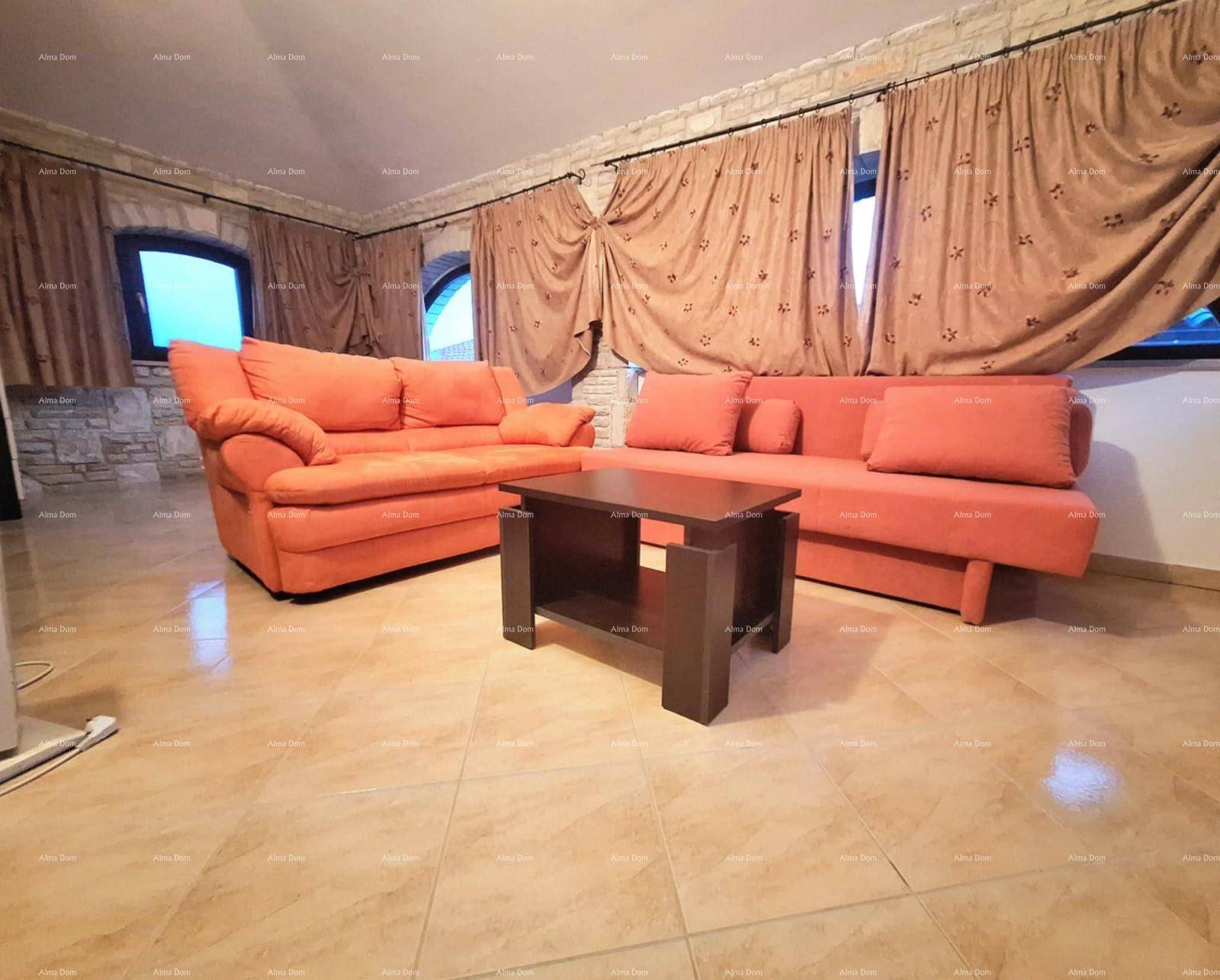 Gemütliches Wohnzimmer mit orangefarbenen Sofas, Couchtisch und rustikalen Steinwänden.