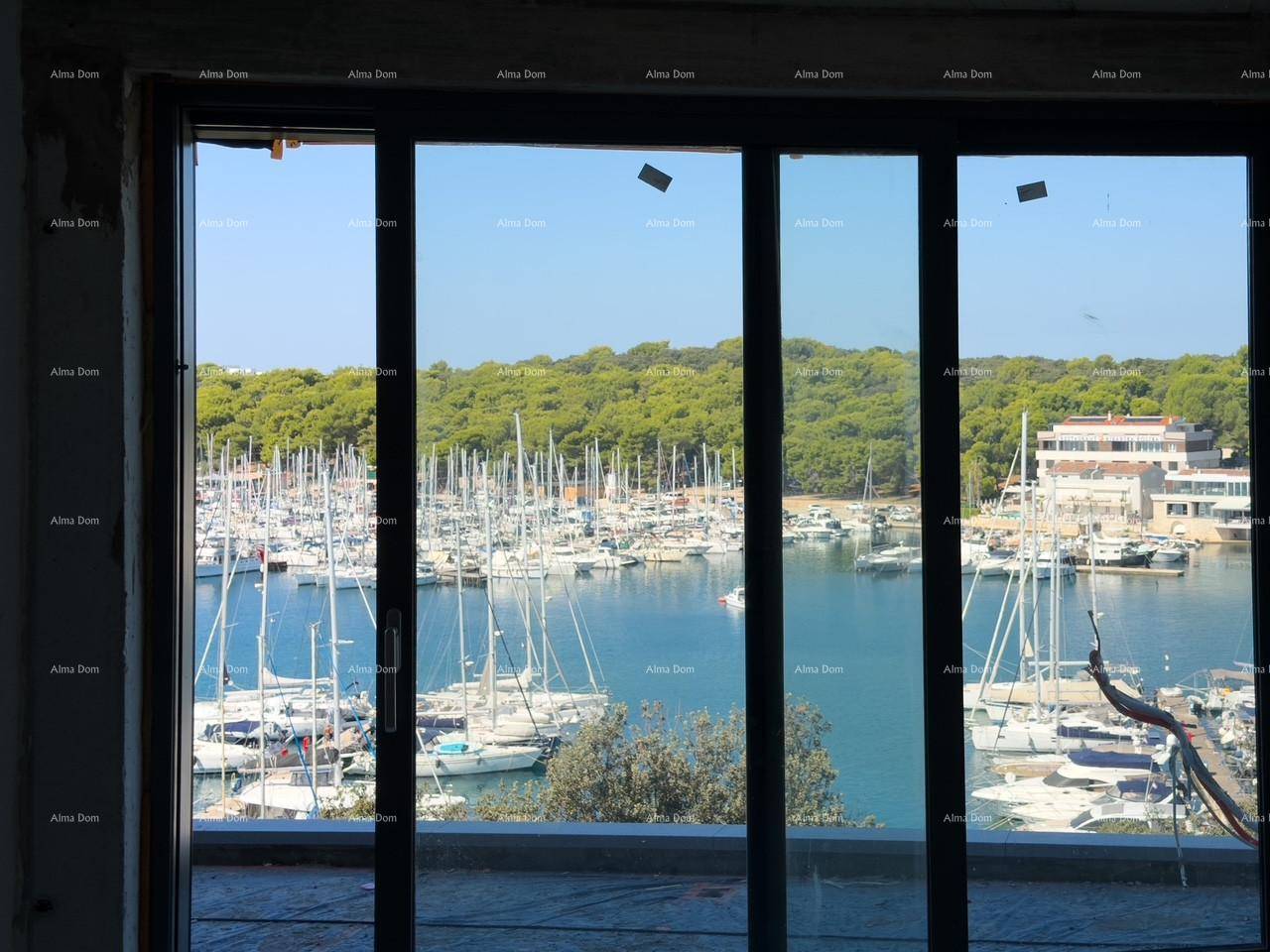 Große Fensterfront mit beeindruckendem Blick auf den belebten Yachthafen und die umliegende Natur.
