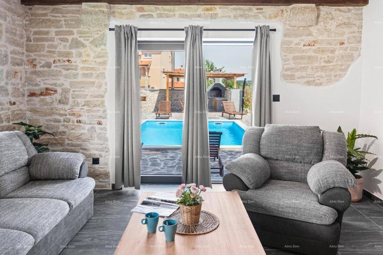 Wohnzimmer mit bequemen Sofas und großer Glastür, die einen direkten Blick auf den Poolbereich ermöglicht.