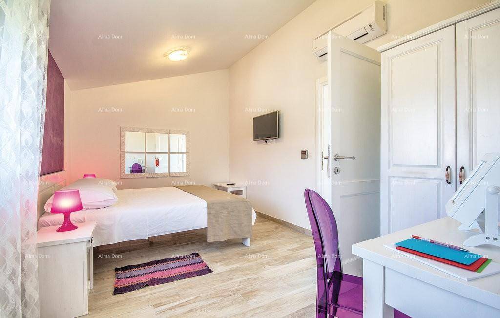 Schlafzimmer mit violetter Akzentwand, Klimaanlage und hellem Interieur.