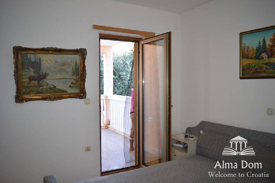 Schlafzimmer mit Zugang zu einem kleinen Balkon und traditionellen Gemälden an den Wänden.