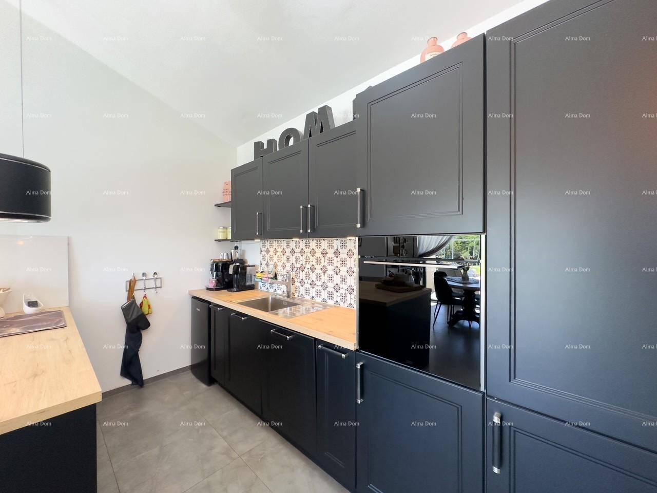 Elegante Küche mit schwarzen Einbauschränken, integriertem Backofen und heller Arbeitsplatte.