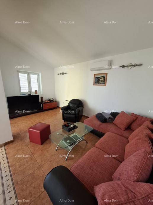 Helles Wohnzimmer mit Fliesenboden, rotem Ecksofa und Klimaanlage an der Wand.
