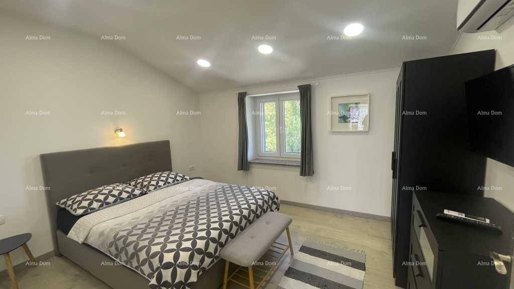 Schlafzimmer mit Doppelbett, dunklem Kleiderschrank und Fenster für natürliches Licht.