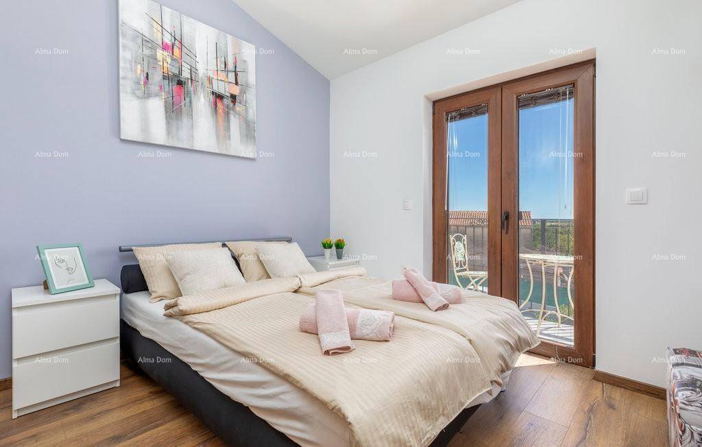 Gemütliches Schlafzimmer mit Doppelbett, Holzboden und Zugang zu einem kleinen Balkon mit Aussicht.