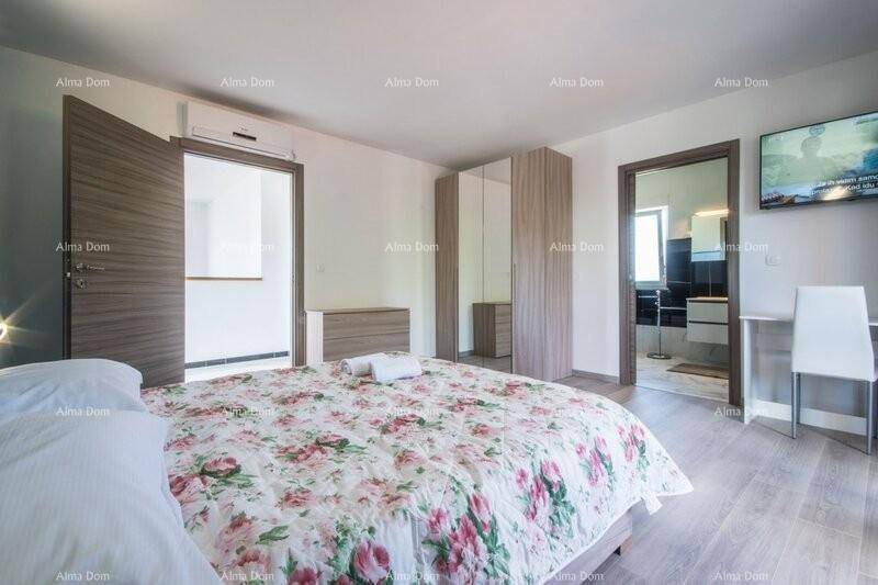 Geräumiges Schlafzimmer mit Doppelbett, Kleiderschrank und Zugang zum angrenzenden Badezimmer.