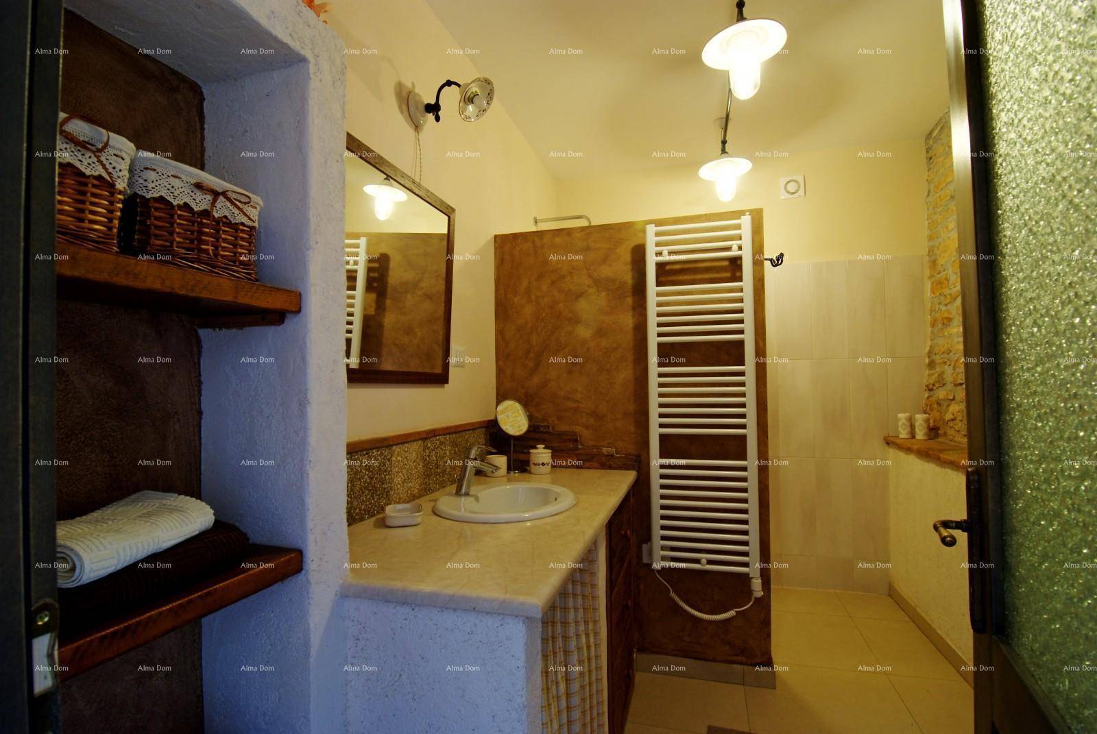 Badezimmer mit Einzelwaschbecken, Spiegel und einem praktischen beheizten Handtuchhalter.