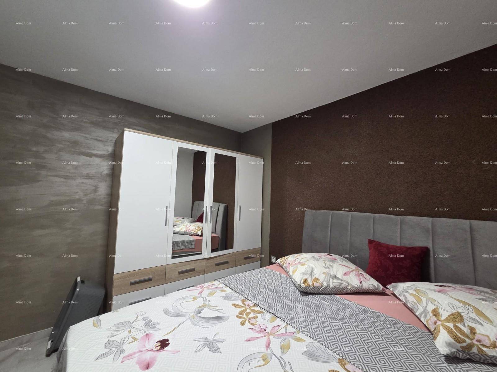 Gemütliches Schlafzimmer mit großem Bett, Kleiderschrank und dunklen Akzentwänden.