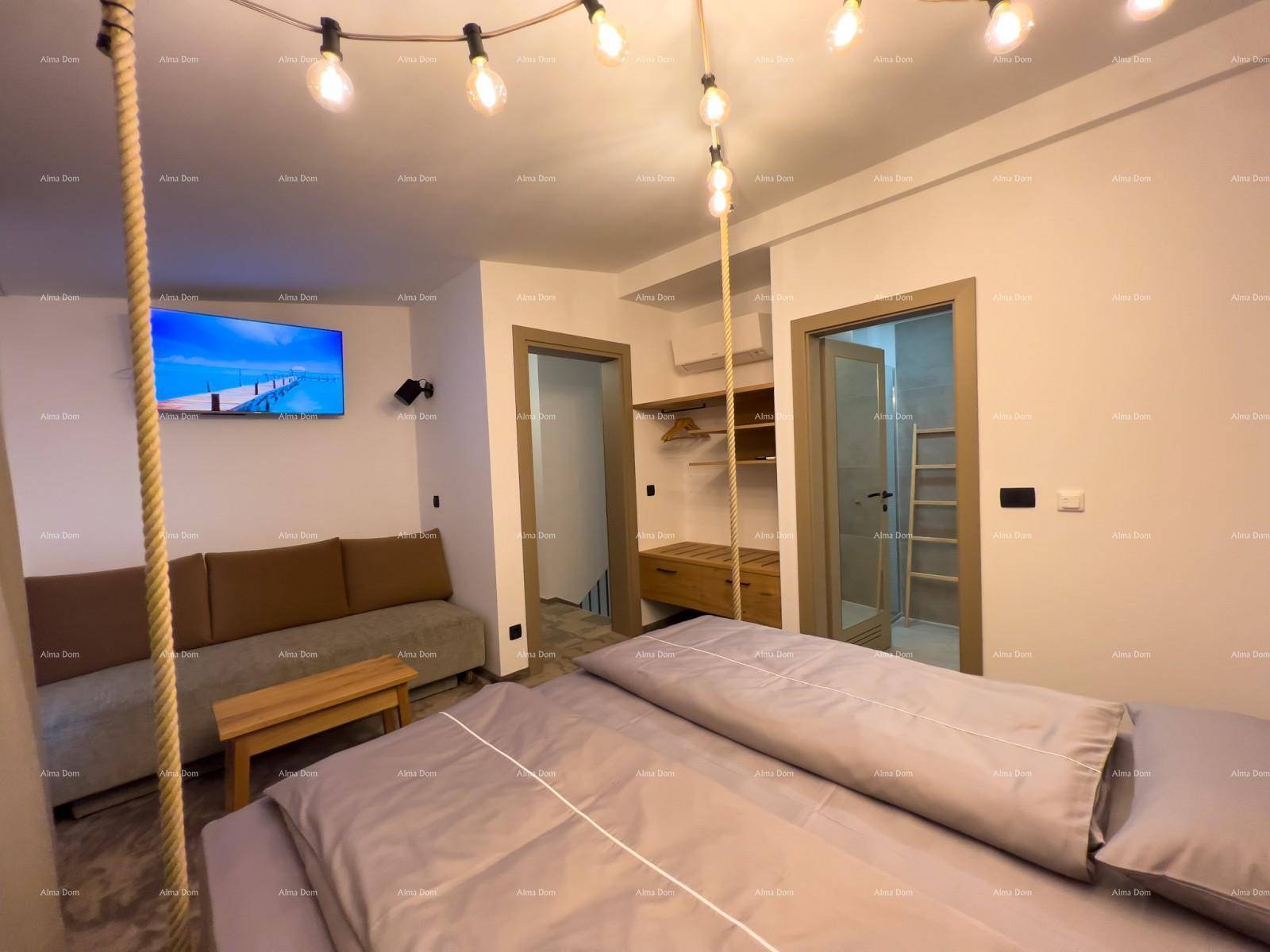 Schlafzimmer mit Bett, Sofa, Fernseher und Blick in den Flur, der den Raum funktional verbindet.