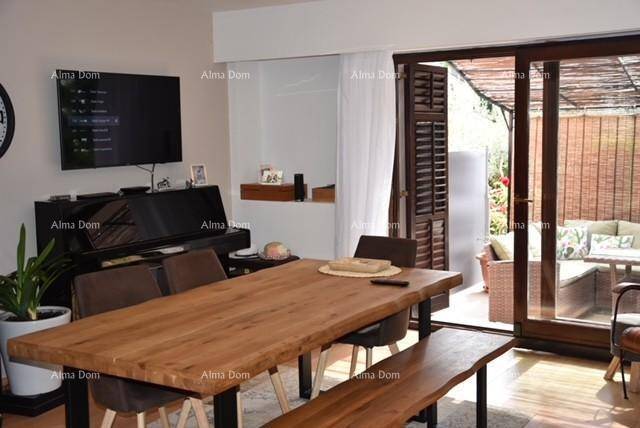 Geräumiger Wohn- und Essbereich mit Klavier, Fernseher und großen Fenstern zur Terrasse.