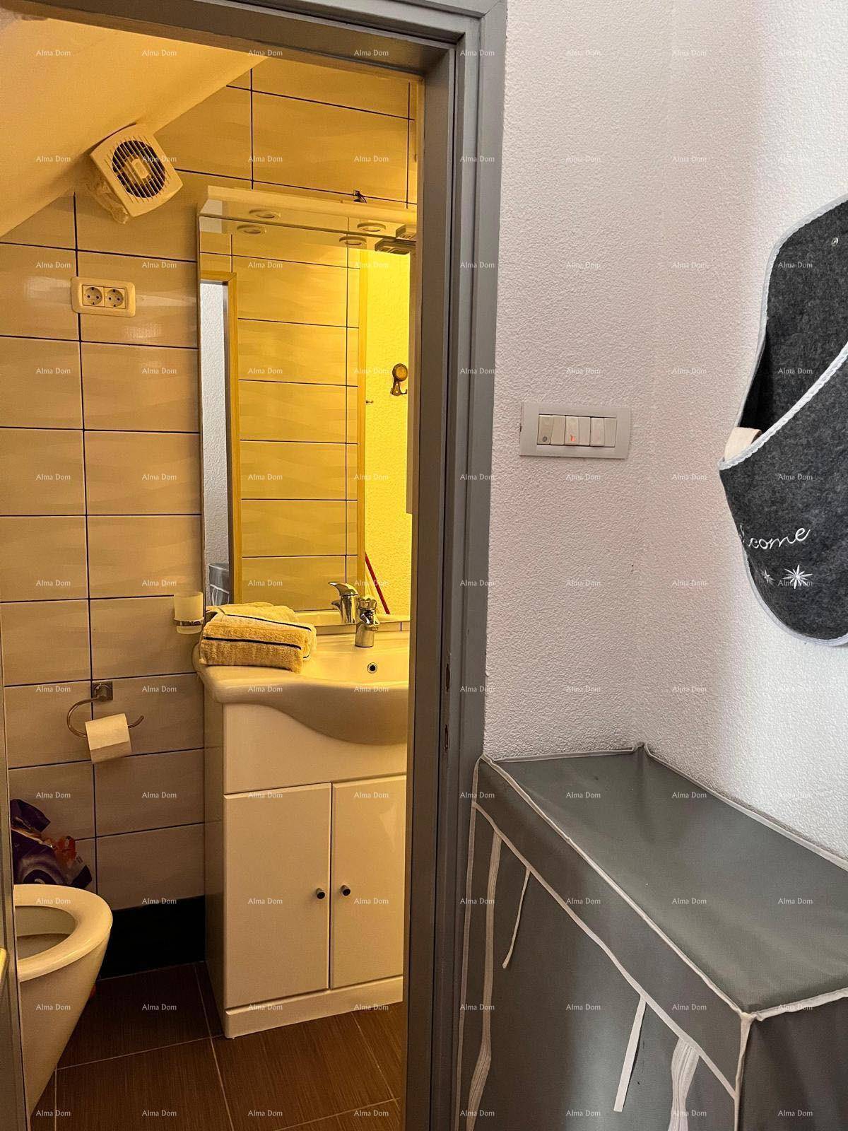Badezimmer mit Waschbecken, Toilette und einem Abluftventilator an der Decke.