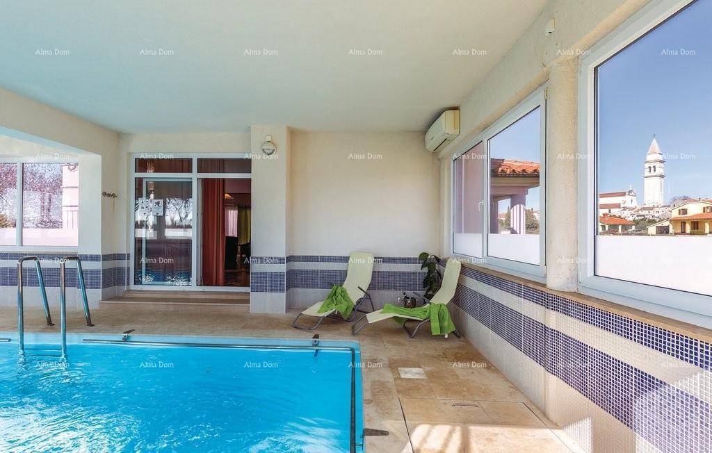 Innenpoolbereich mit Liegestühlen, Klimaanlage und Blick auf die Stadt.