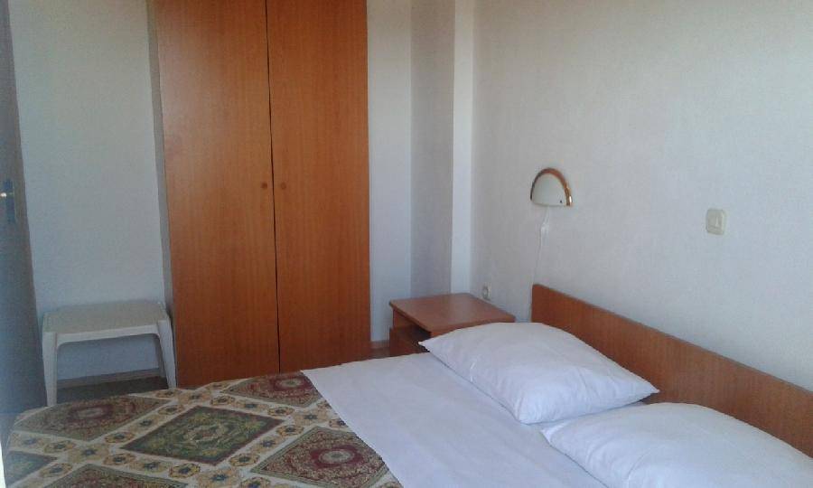 Helles Schlafzimmer mit einem bequemen Bett und einem großen Holzschrank, der viel Stauraum bietet. 