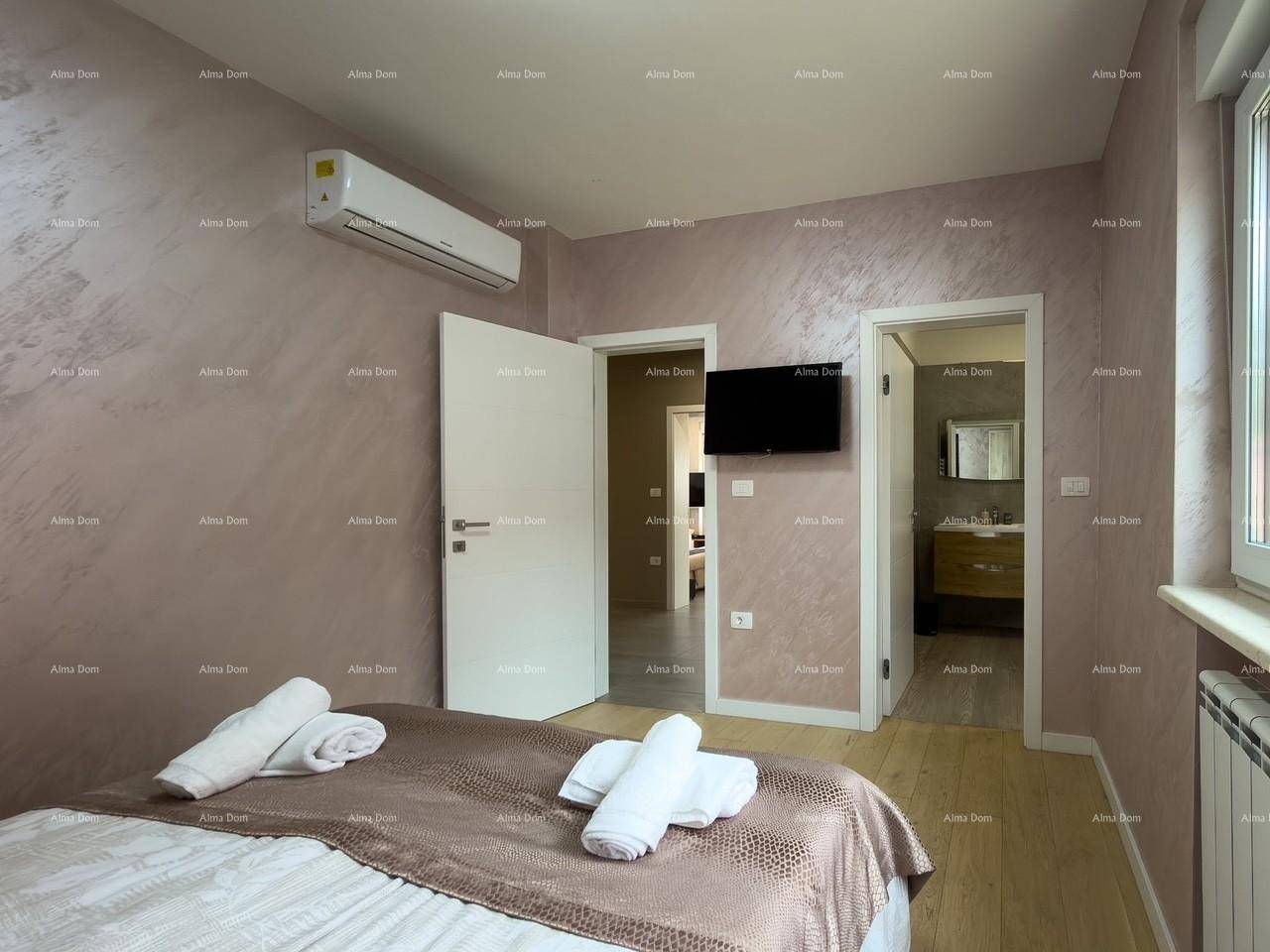 Schlafzimmer mit Klimaanlage, Fernseher und Zugang zu Bad und Flur.