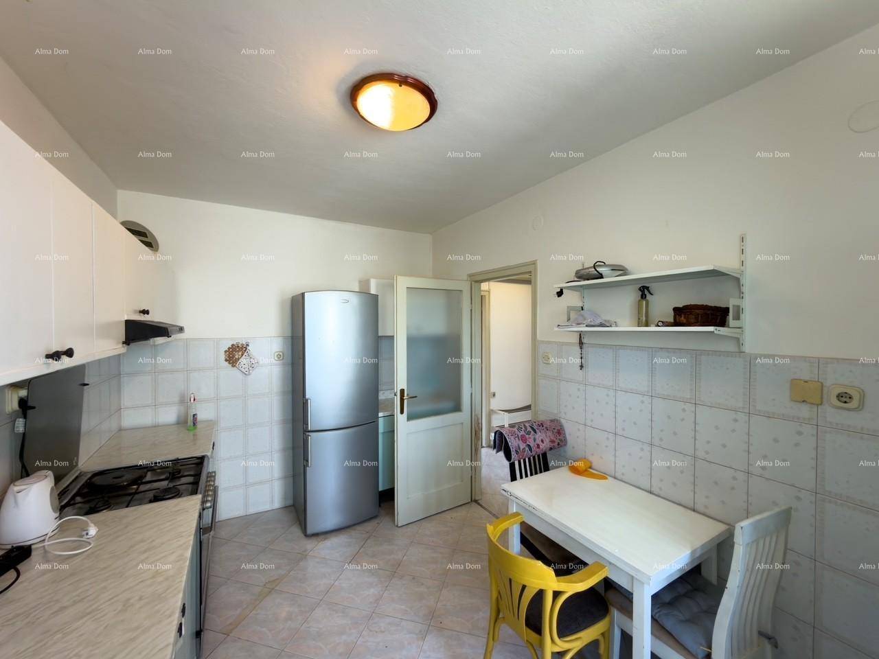 Essküche mit Kühlschrank, Esstisch und Zugang zu einem weiteren Raum.