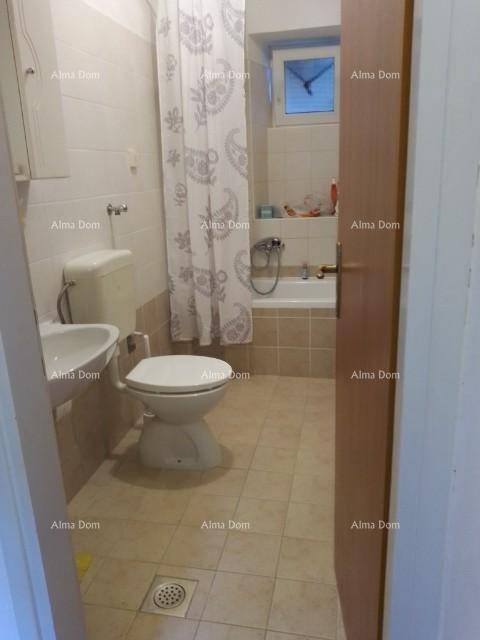 Badezimmer mit Toilette, Waschbecken und Badewanne mit Duschvorhang, hell gefliest.