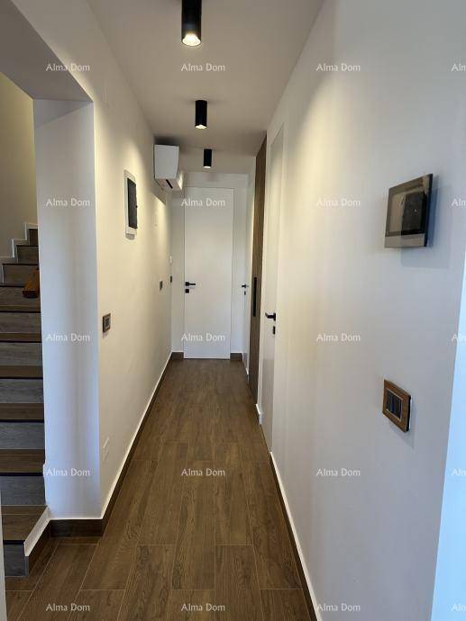 Moderner Flur mit Holztreppe und schlichten weißen Wänden.