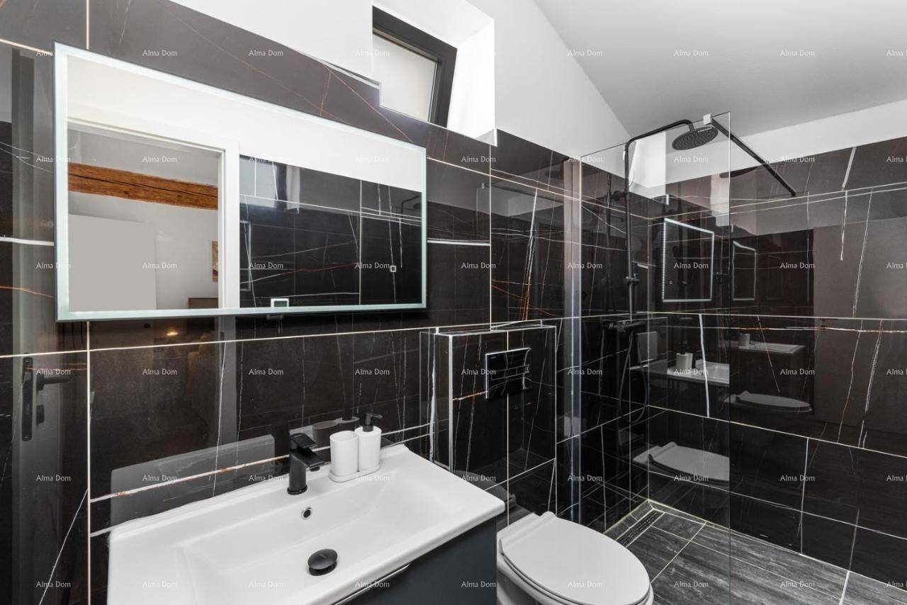 Stilvolles Badezimmer mit Waschtisch, Toilette und begehbarer Dusche, komplett in dunklen Marmorfliesen gehalten.