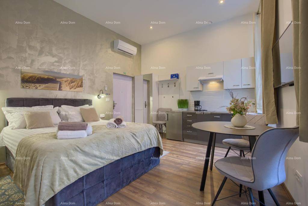 Modernes Schlafzimmer mit Doppelbett, integrierter Küchenzeile und kleinem Essbereich.