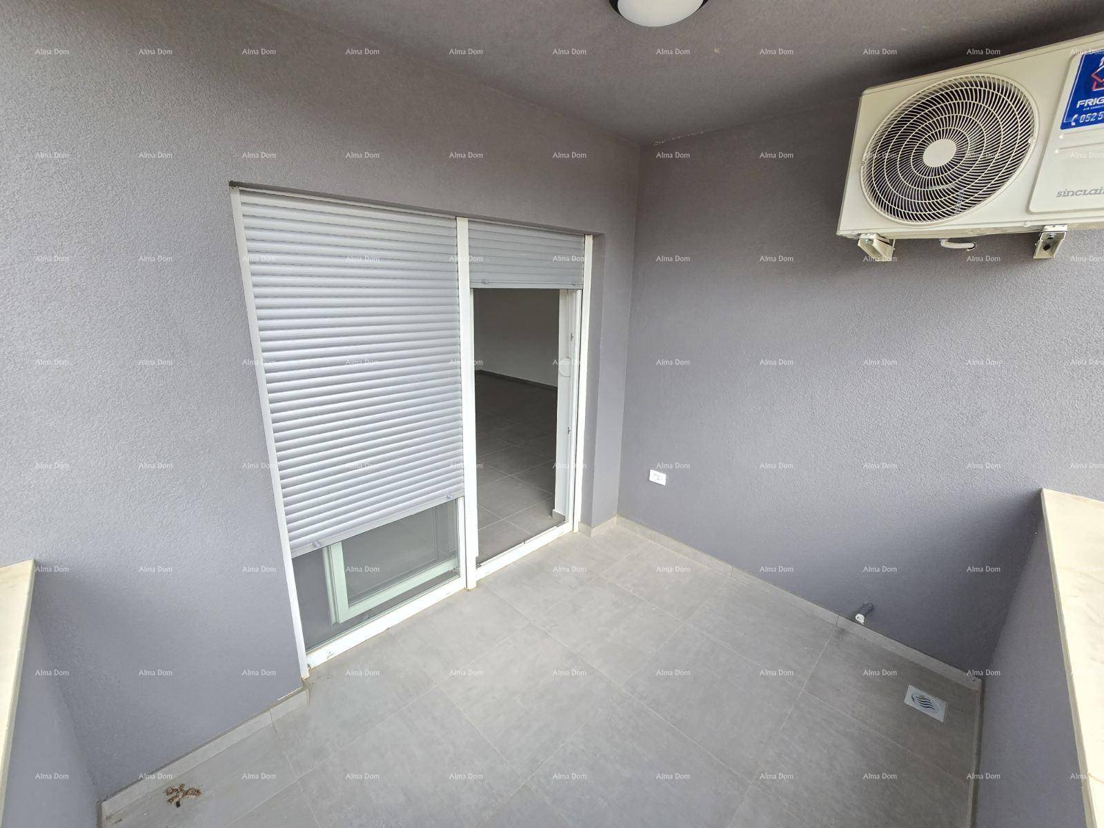Überdachter Balkon mit grauen Fliesen, Rollladen und einer Klimaanlage an der Wand.