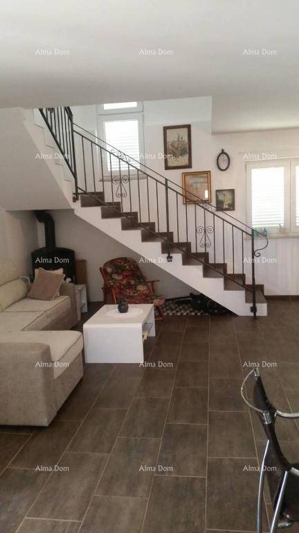 Gemütlicher Wohnbereich mit Sofa, Couchtisch und einer eleganten Treppe mit schmiedeeisernem Geländer.