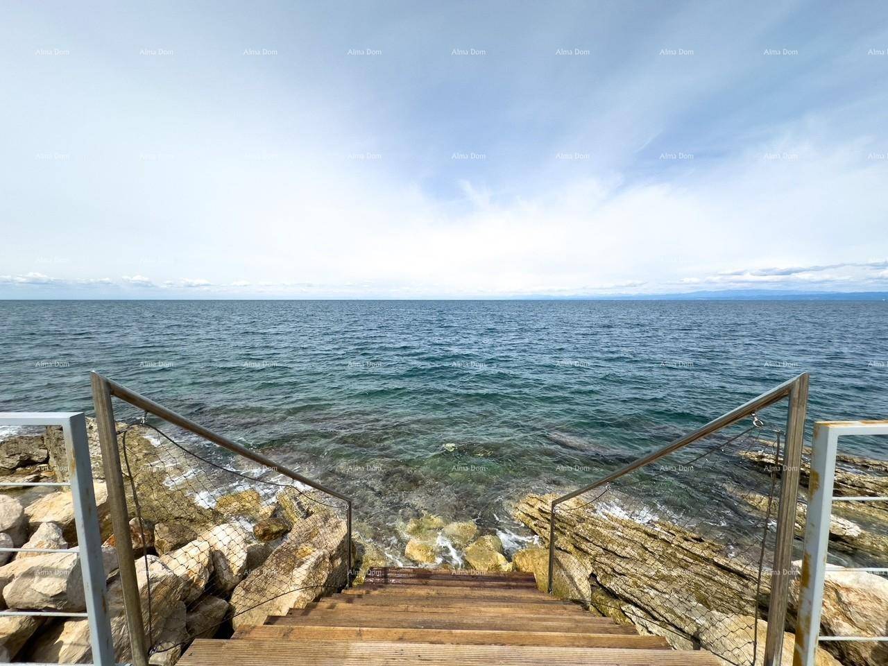 Holztreppe führt über Felsen direkt ins klare, blaue Meerwasser.