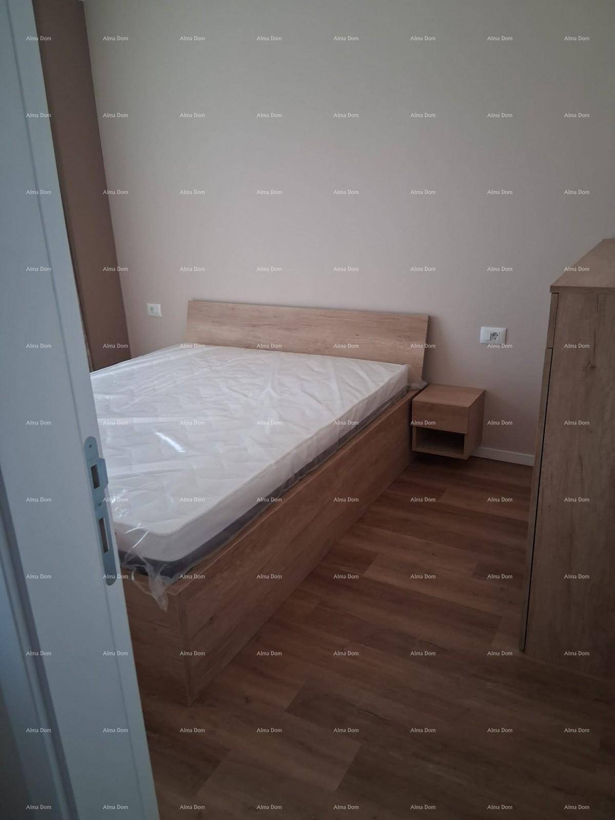 Schlafzimmer mit neuem Holzbett, Nachttisch und Laminatboden in heller Holzoptik.