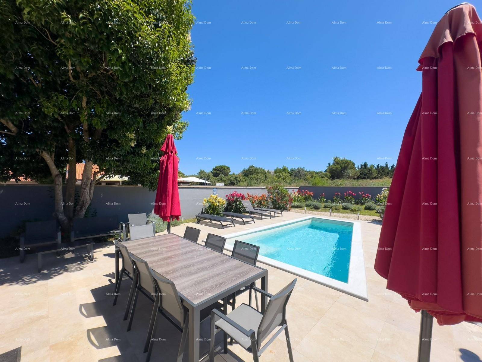 Gemütlicher Essbereich im Freien mit großem Tisch, roten Sonnenschirmen und Blick auf den Pool.