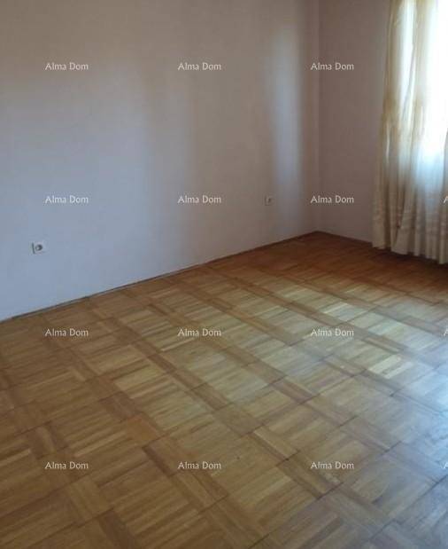 Geräumiges Zimmer mit Parkettboden und Fenster, das viel Tageslicht hereinlässt.