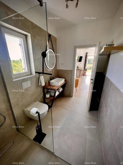 Modernes Badezimmer mit begehbarer Dusche, Fenster und minimalistischem Design.