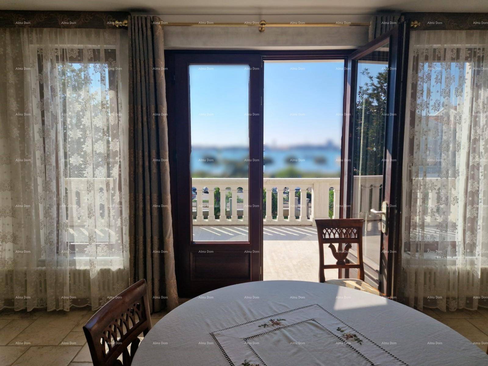 Heller Innenraum mit Zugang zu einem Balkon und weitem Blick auf das Meer.
