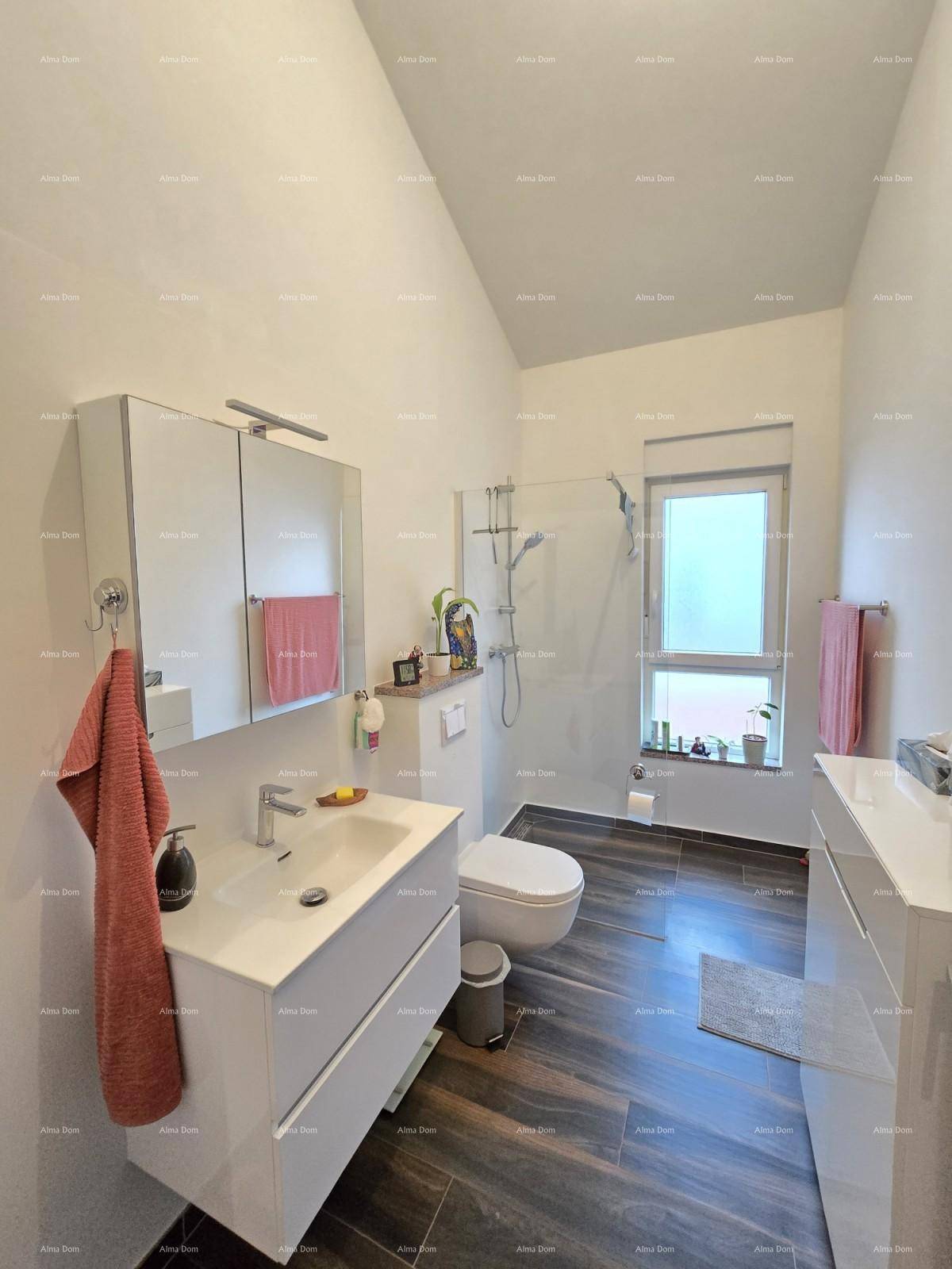 Helles Badezimmer mit Waschtisch, WC, Dusche und Fenster.