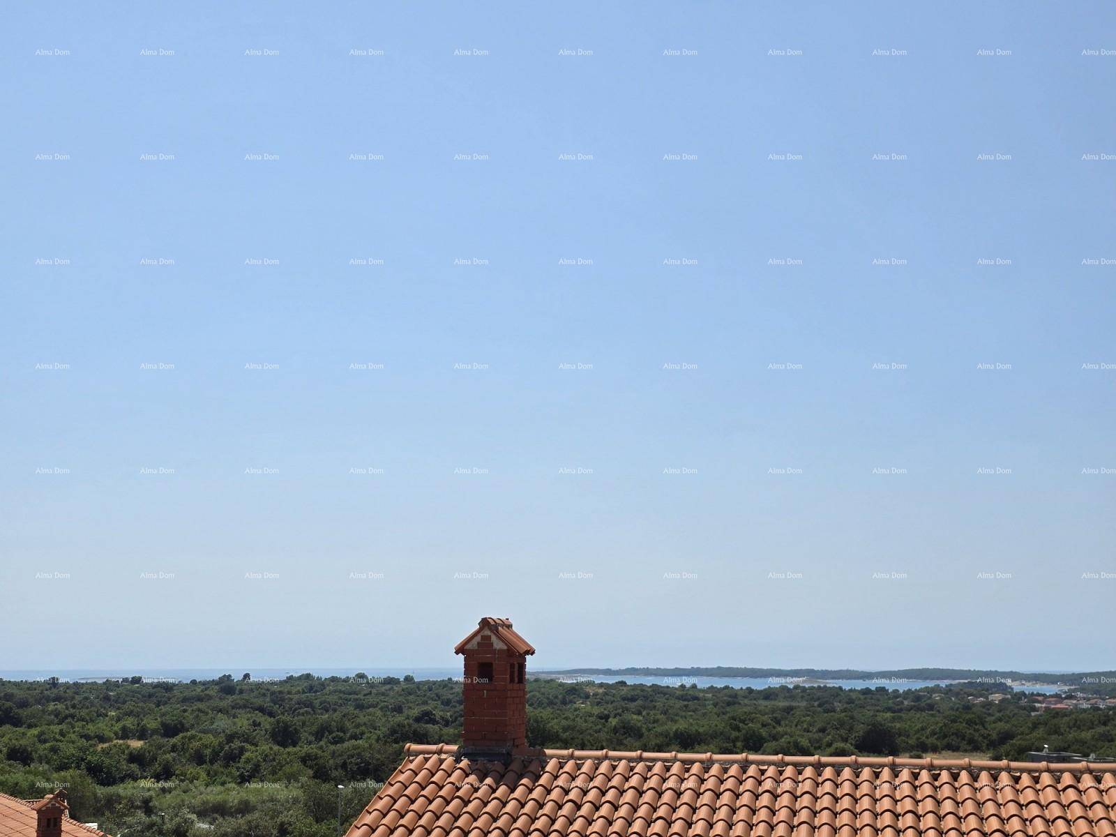 Aussicht über ein Ziegeldach mit Schornstein, grüne Bäume und das weite Meer am Horizont.