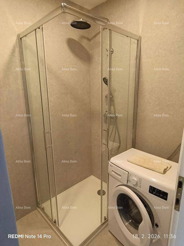 Modernes Badezimmer mit Duschkabine, Waschmaschine und hellen Fliesen.