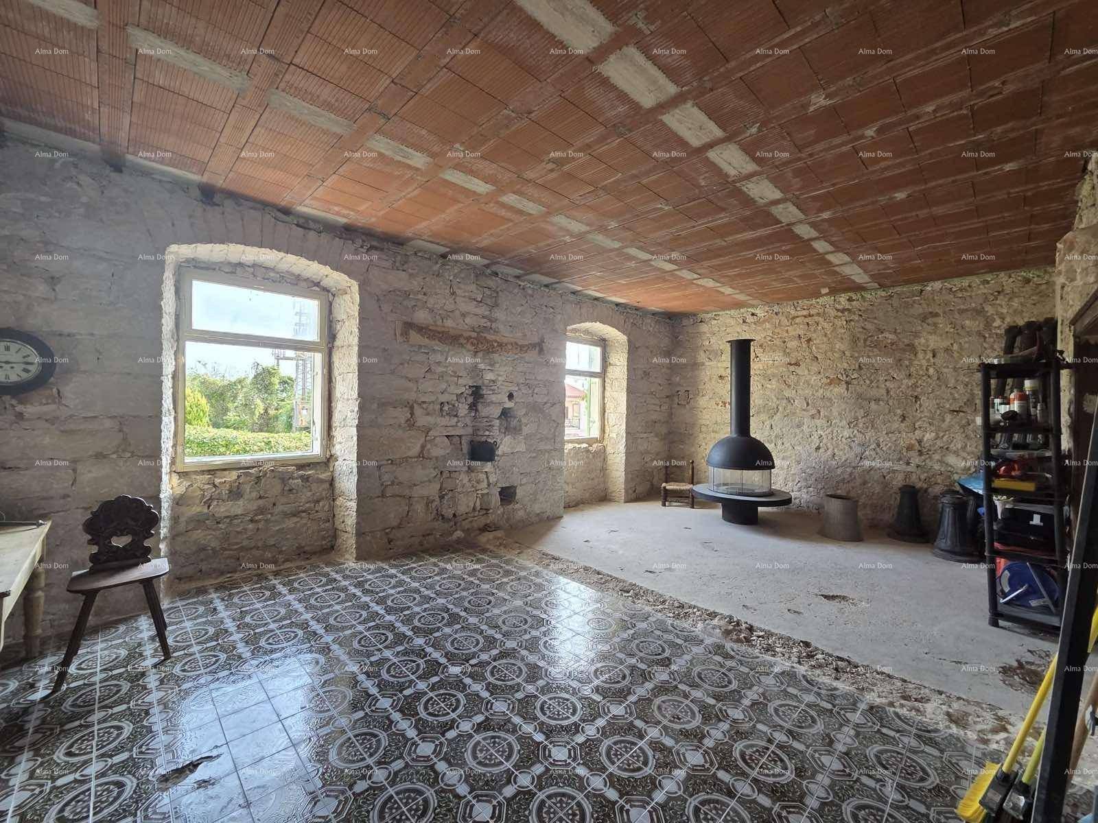 Geräumiger Innenraum mit freiliegenden Steinwänden, Ziegeldecke und einem modernen freistehenden Kamin.