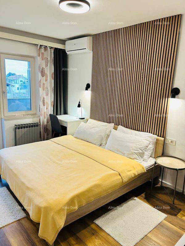 Gemütliches Schlafzimmer mit Holzboden, Akzentwand und großem Fenster für viel Tageslicht.