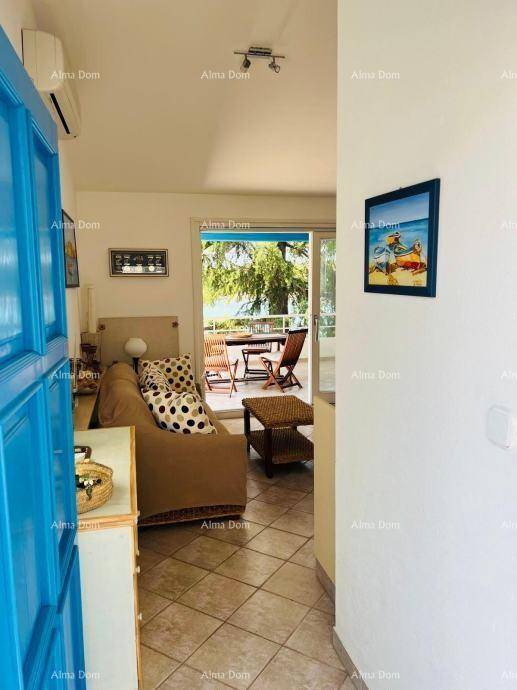 Eingangsbereich führt in einen gemütlichen Wohnbereich mit Sofa und Zugang zur Terrasse mit Meerblick.