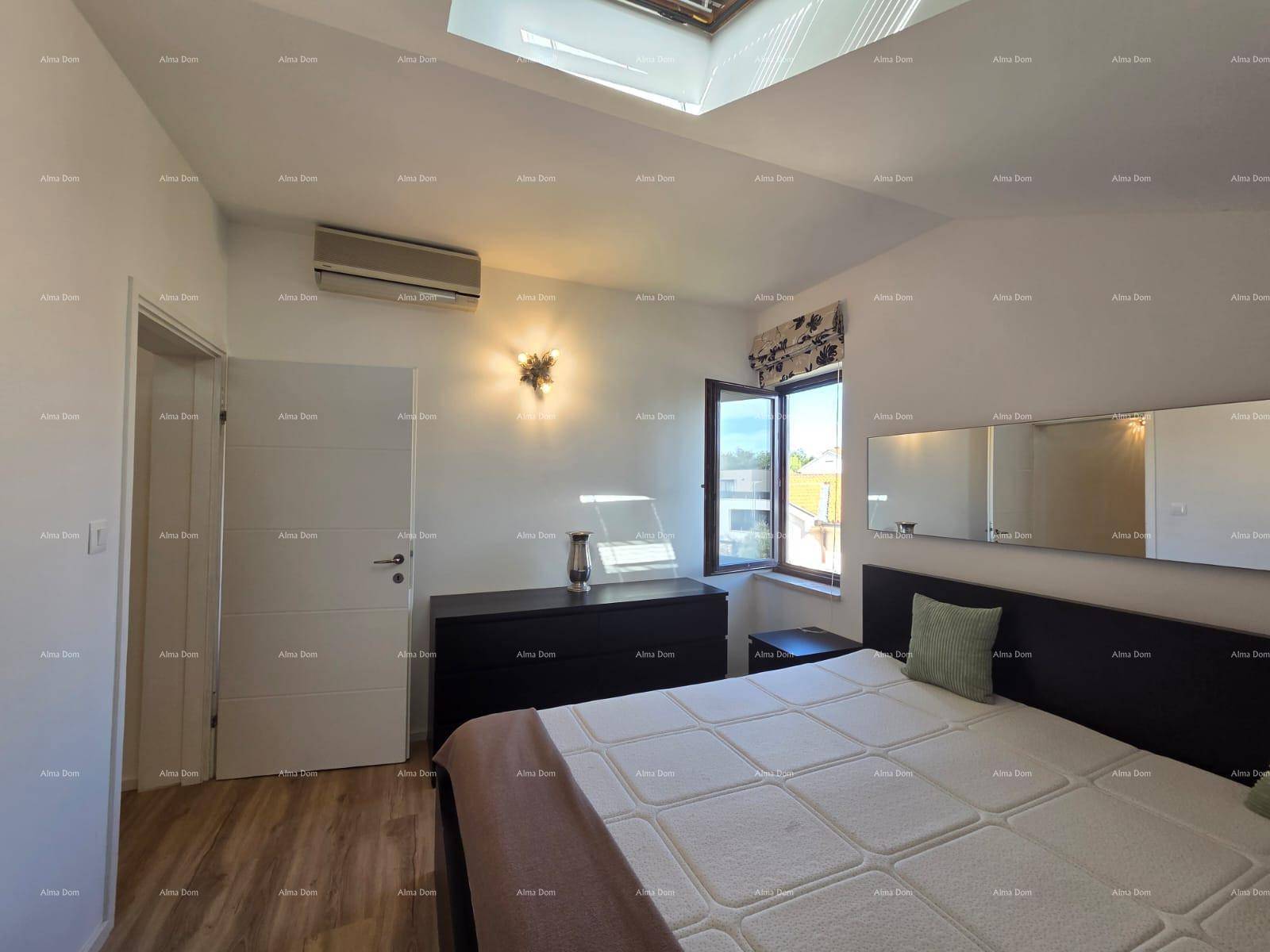 Gemütliches Schlafzimmer mit Klimaanlage, Holzboden und einem Fenster, das für natürliche Belüftung sorgt.