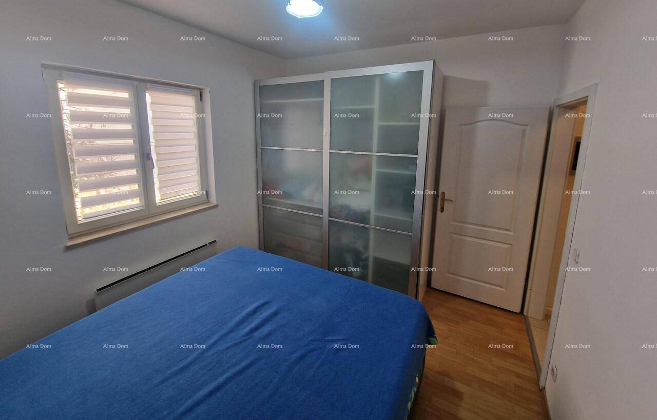 Schlafzimmer mit Doppelbett, Kleiderschrank und Fenster mit Jalousien.