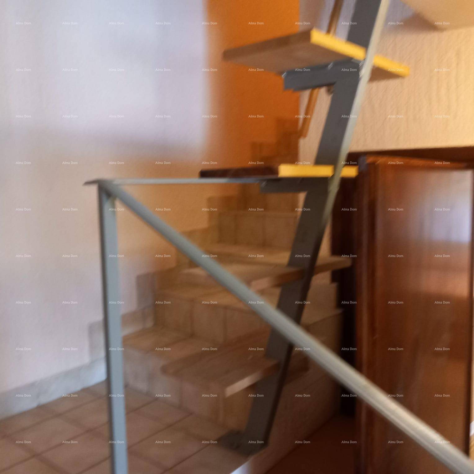 Treppenaufgang mit Metallgeländer und Blick auf die nächste Etage des Hauses.