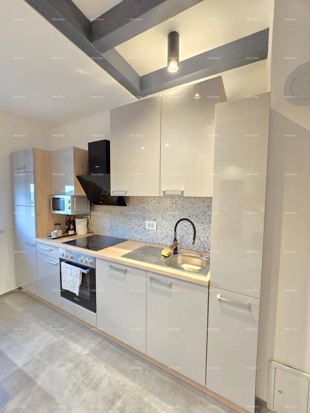 Moderne Einbauküche mit glänzenden grauen Fronten, Induktionskochfeld und integrierten Elektrogeräten.
