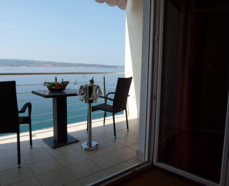 Privater Balkon mit Tisch und Stühlen, ideal für Mahlzeiten mit herrlichem Meerblick.