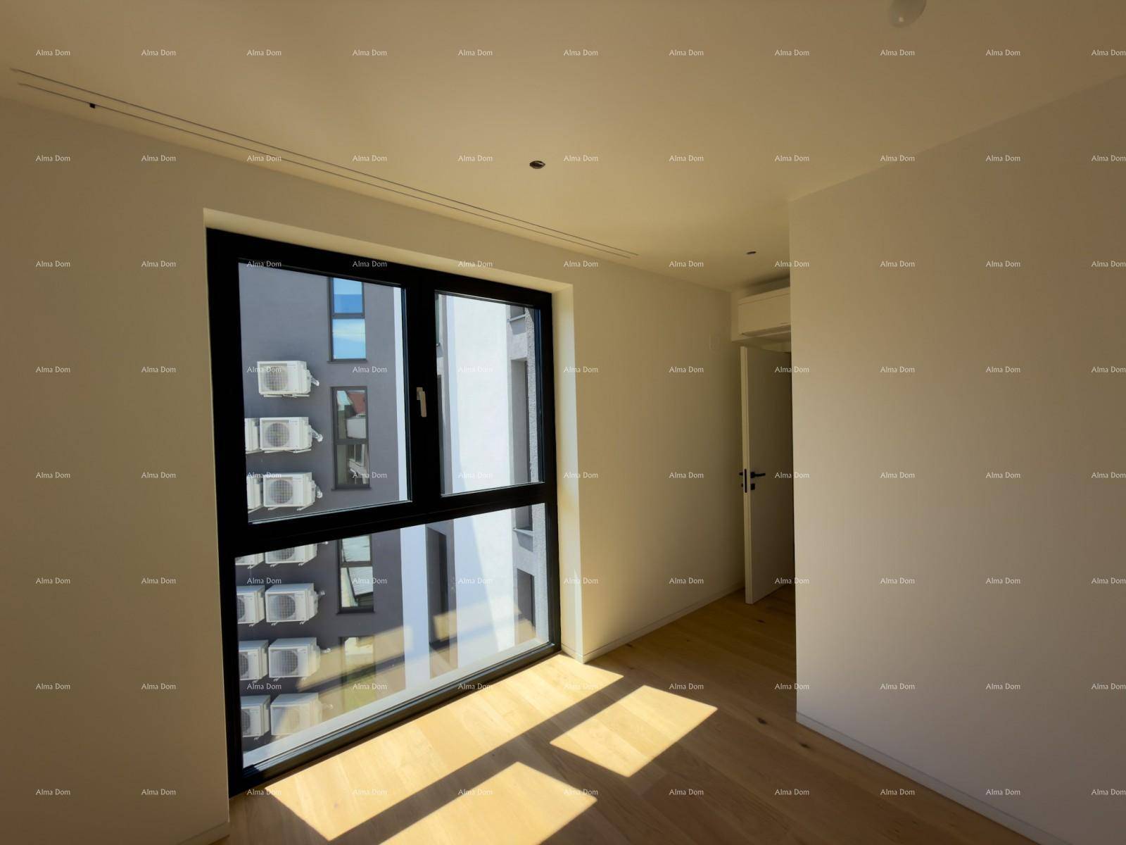 Geräumiges Zimmer mit Holzboden und großem Fenster, das den Raum hell erleuchtet.
