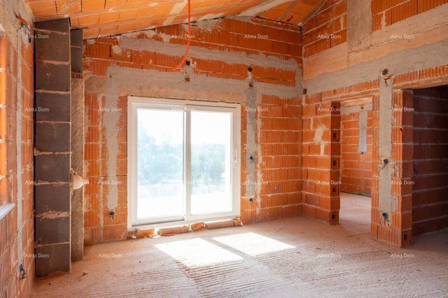 Geräumiger Raum im Rohbau mit großer Schiebetür und viel natürlichem Licht.